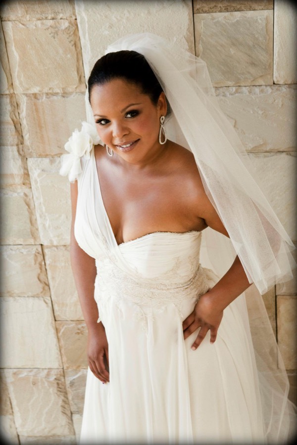 Bride in a strapless gown with a cathedral veil drawn over one shoulder