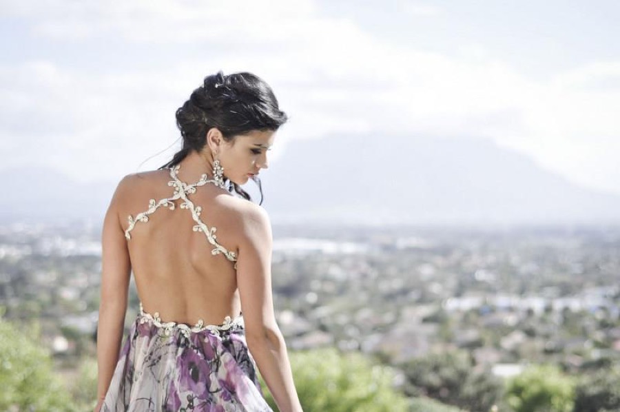 Open back of a floral chiffon gown, halter tie and mountain view behind