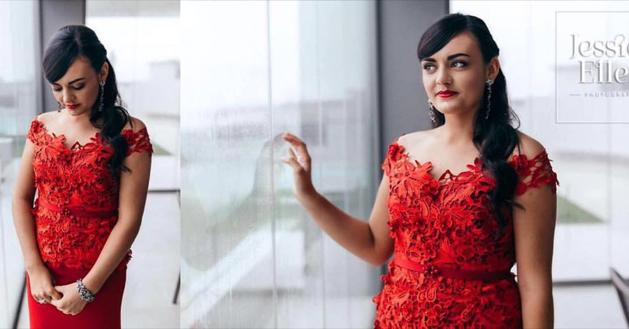 Scarlet gown caught mid-turn against a white wall