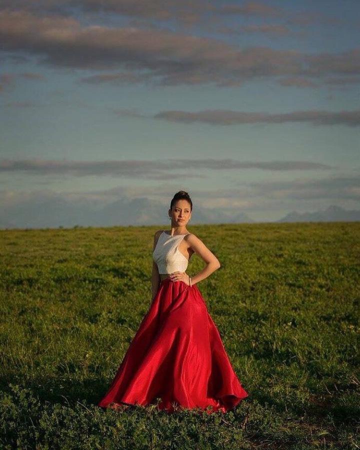White and gold gown photographed in an open field at dusk