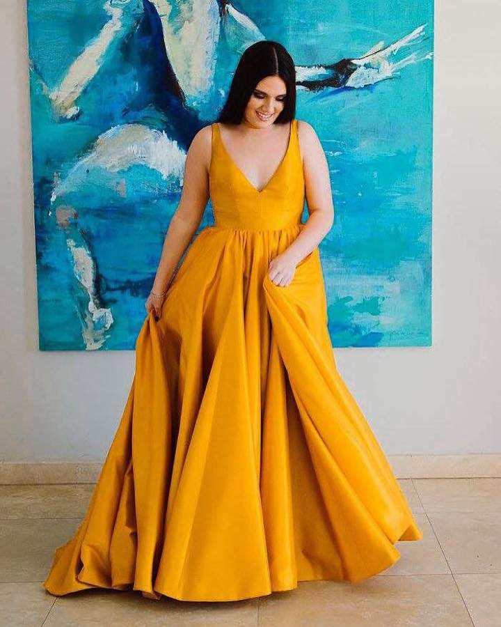 Mustard satin gown with a high slit and draped bodice